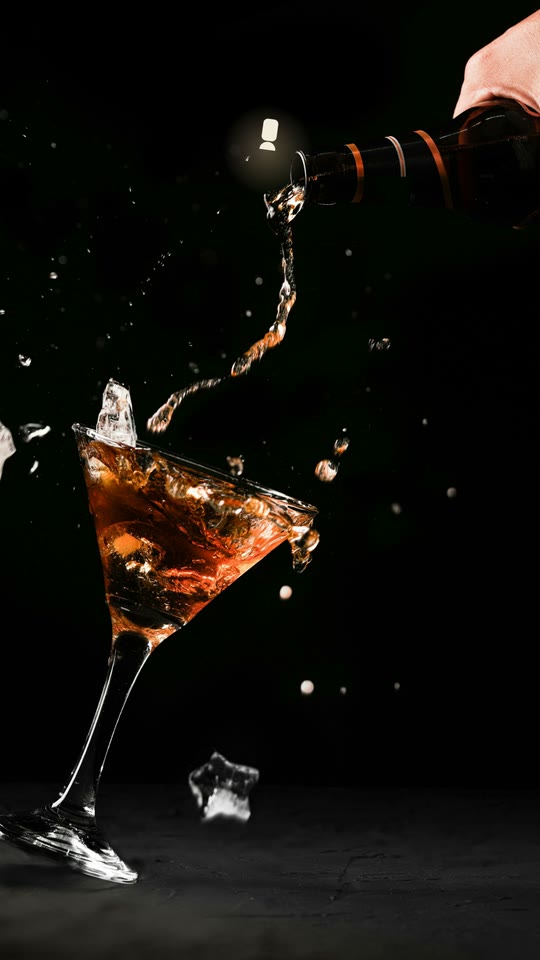 A frame from the film: a cocktail splashing, lit on the beat